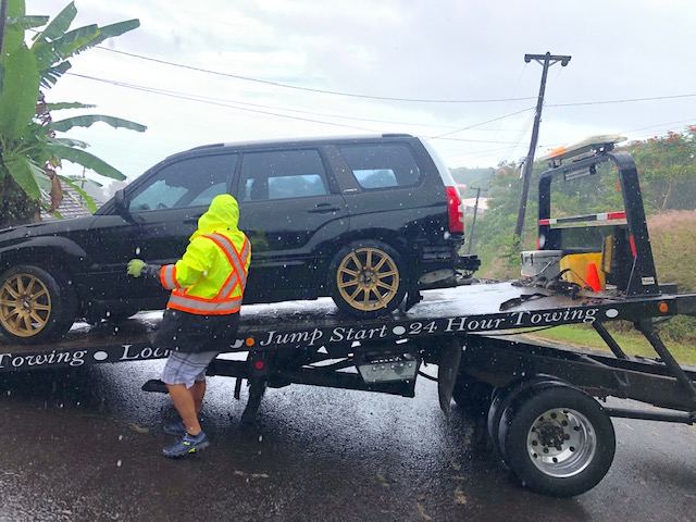 Driver in hi-vis loading an SUV onto the flatbed